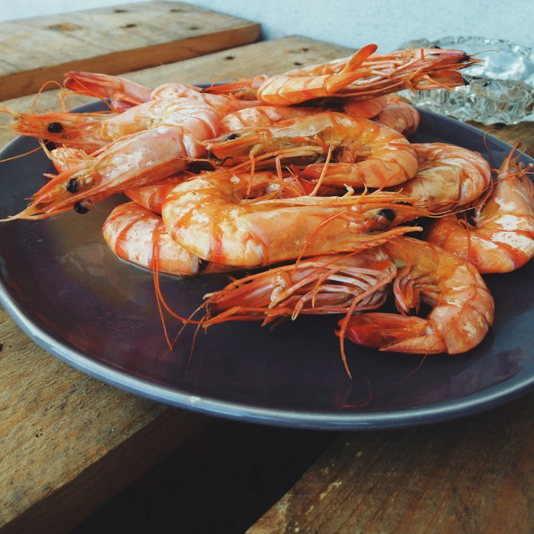 A plate of shrimp on a wooden table